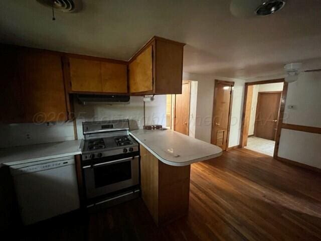 819 Ave N, Sunray, TX 79086 - kitchen with stainless steel range with gas stovetop, white dishwasher, exhaust hood, a peninsula, and dark wood finished floors