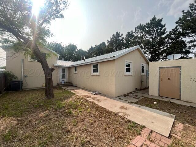 819 Ave N, Sunray, TX 79086 - back of house with stucco siding, a shed, and a metal roof