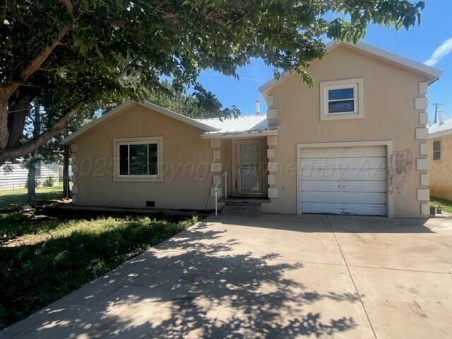 819 Ave N, Sunray, TX 79086 - view of front facade with a garage, stucco siding, and driveway