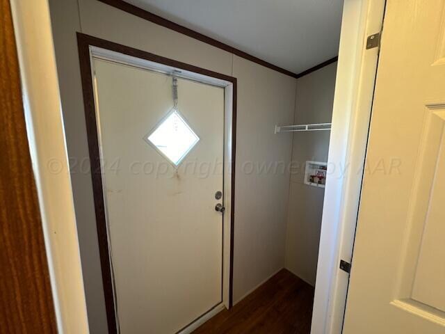 doorway featuring wood-type flooring and ornamental molding