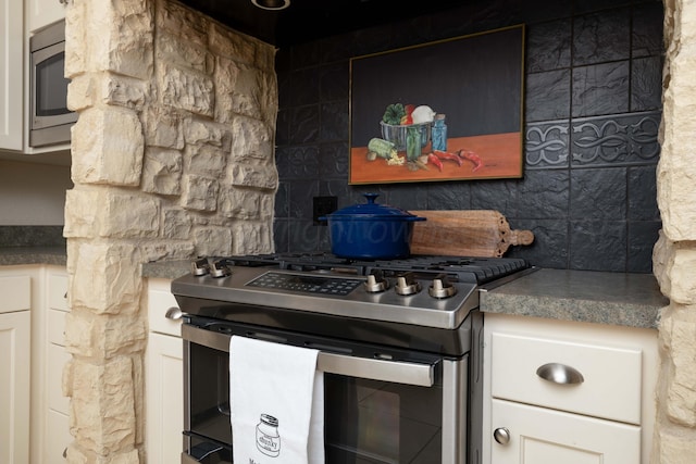 5007 Wesley Rd, Amarillo, TX 79119 - kitchen with stainless steel appliances, decorative backsplash, white cabinetry, and dark countertops