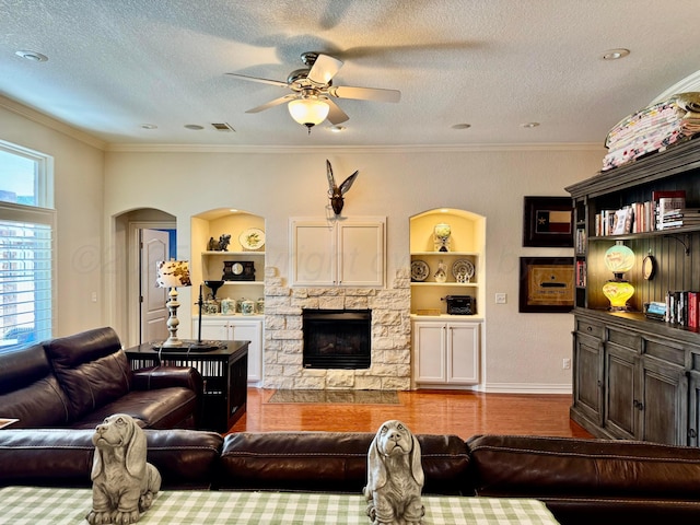 5007 Wesley Rd, Amarillo, TX 79119 - living area with a stone fireplace, a ceiling fan, wood finished floors, built in features, and arched walkways