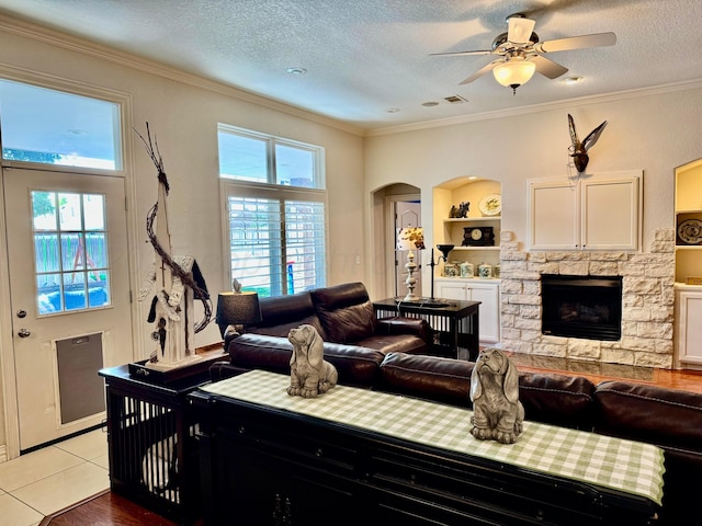 5007 Wesley Rd, Amarillo, TX 79119 - living room with healthy amount of natural light, a fireplace, ceiling fan, ornamental molding, and arched walkways