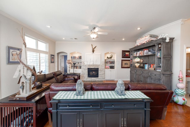 5007 Wesley Rd, Amarillo, TX 79119 - living room with arched walkways, a ceiling fan, a fireplace, wood finished floors, and crown molding