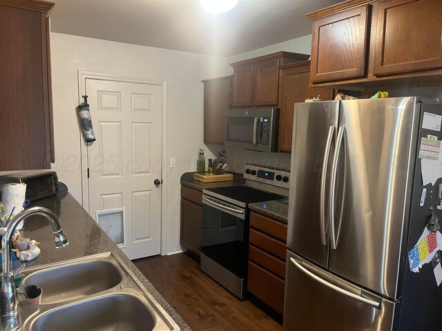 4406 S Roberts St, Amarillo, TX 79118 - kitchen featuring appliances with stainless steel finishes, a sink, dark countertops, and dark wood-style floors