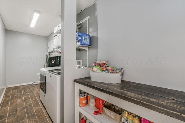 clothes washing area with baseboards, dark wood-type flooring, washer and clothes dryer, and laundry area