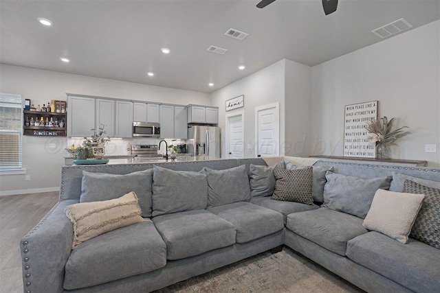 living room with ceiling fan, recessed lighting, and visible vents