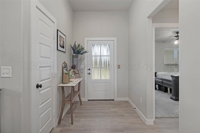 entryway featuring a ceiling fan, baseboards, and light wood-type flooring