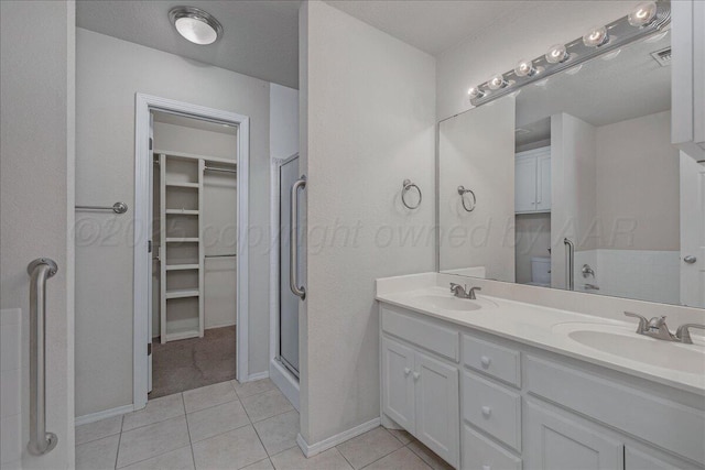 3610 S Mirror St, Amarillo, TX 79118 - full bathroom featuring a spacious closet, double vanity, a shower stall, and tile patterned floors