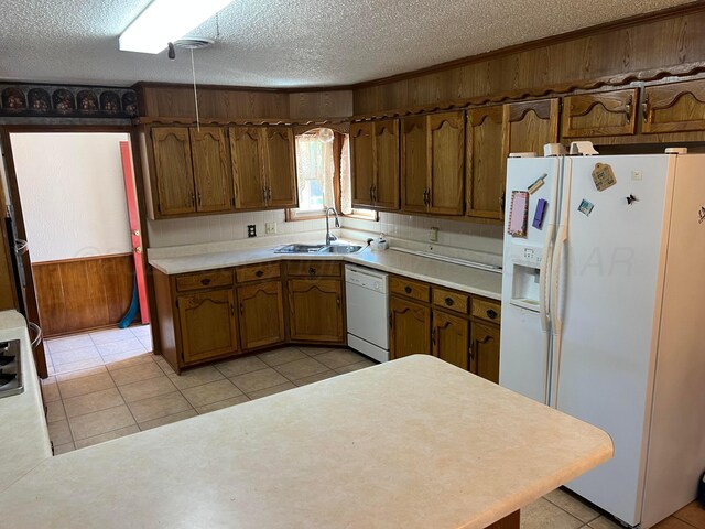 415 Mesquite Ave, Amarillo, TX 79108 - kitchen with white appliances, a sink, wood walls, a textured ceiling, and light countertops