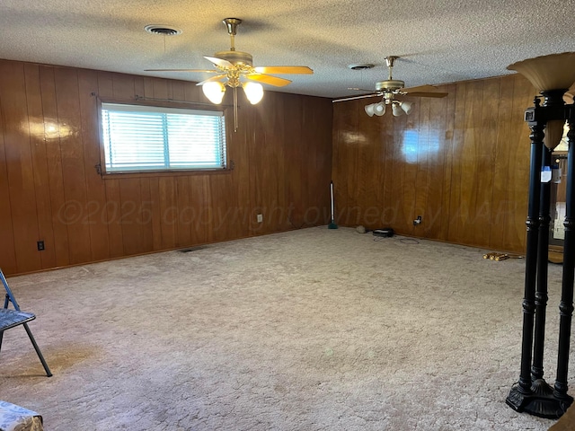 415 Mesquite Ave, Amarillo, TX 79108 - unfurnished living room featuring ceiling fan, a textured ceiling, carpet flooring, and wood walls