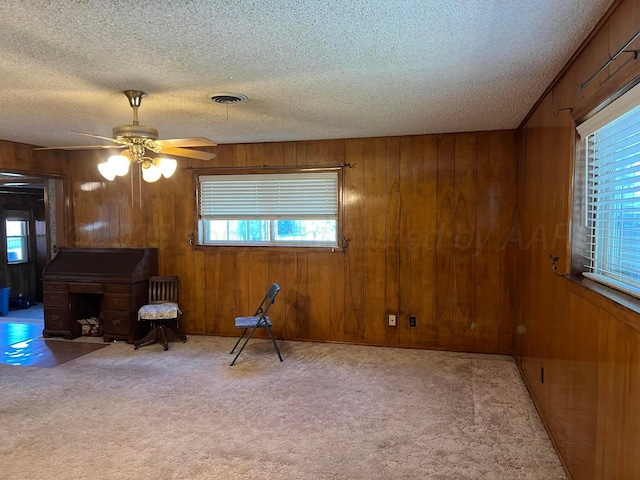 415 Mesquite Ave, Amarillo, TX 79108 - living area featuring a textured ceiling, plenty of natural light, carpet flooring, wooden walls, and ceiling fan