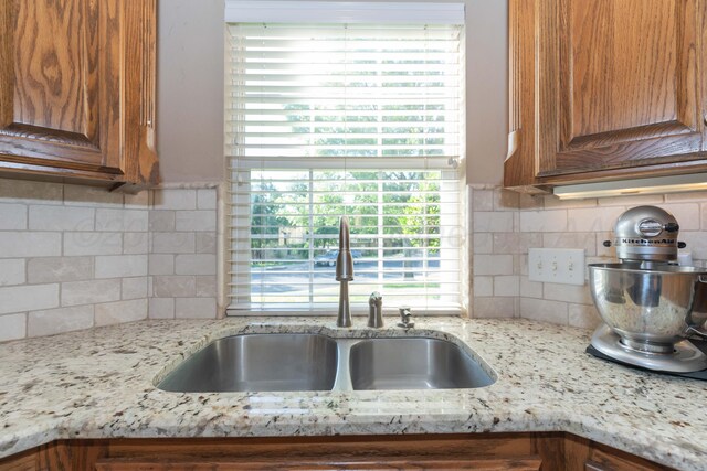 6600 Pepper Tree Pl, Amarillo, TX 79124 - kitchen featuring backsplash, brown cabinets, and light stone countertops