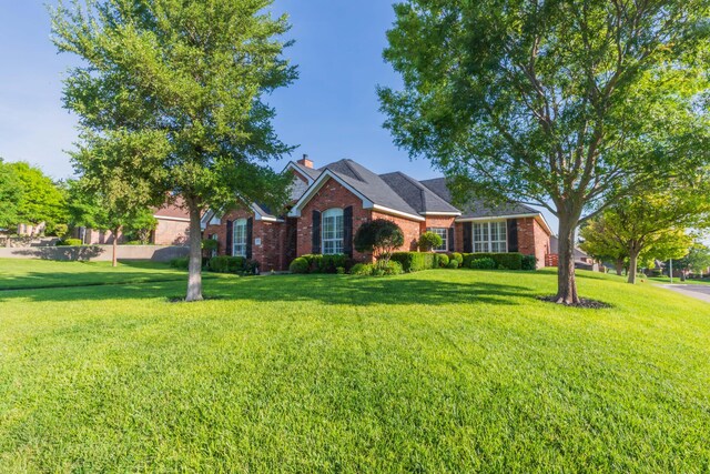 6600 Pepper Tree Pl, Amarillo, TX 79124 - view of front of home featuring brick siding, a front yard, and a chimney