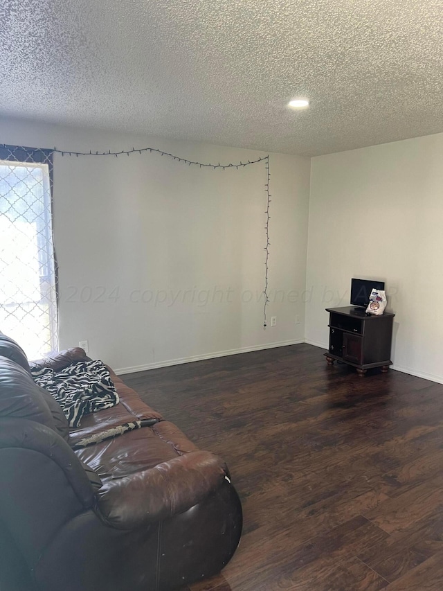 sitting room with a textured ceiling and dark hardwood / wood-style floors