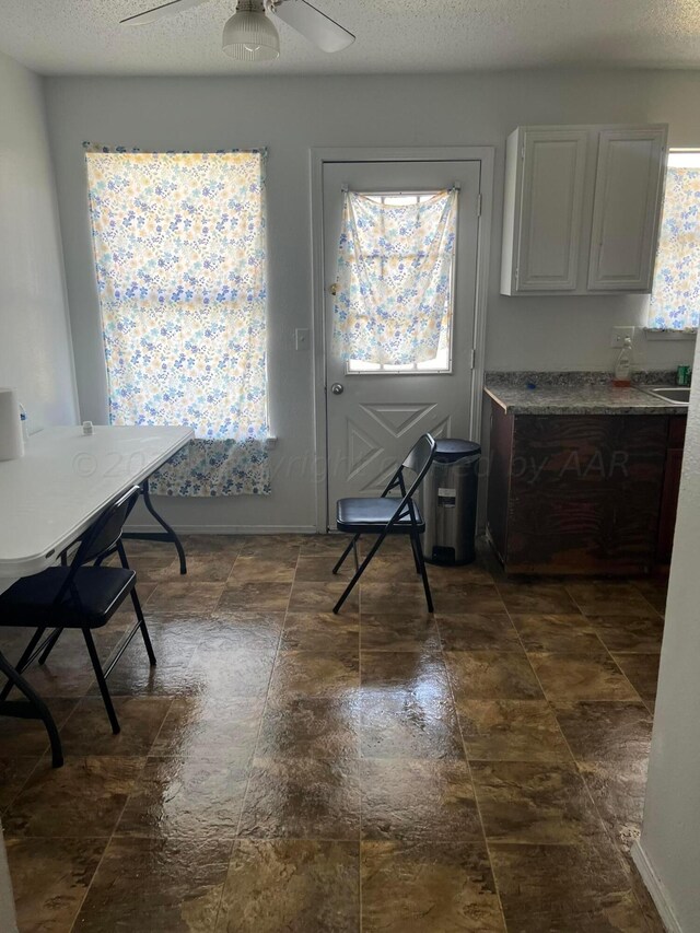 unfurnished room with dark wood-type flooring, a textured ceiling, and ceiling fan