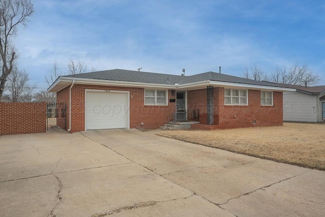 ranch-style house featuring brick siding, roof with shingles, concrete driveway, an attached garage, and fence