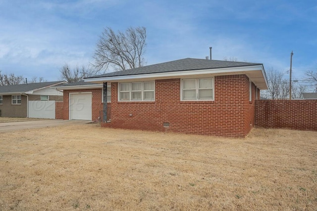 view of front facade with brick siding, roof with shingles, concrete driveway, an attached garage, and fence