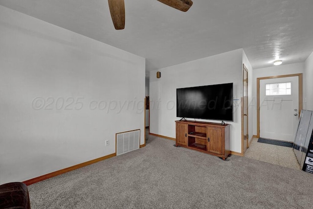 unfurnished living room with carpet floors, baseboards, visible vents, and a ceiling fan