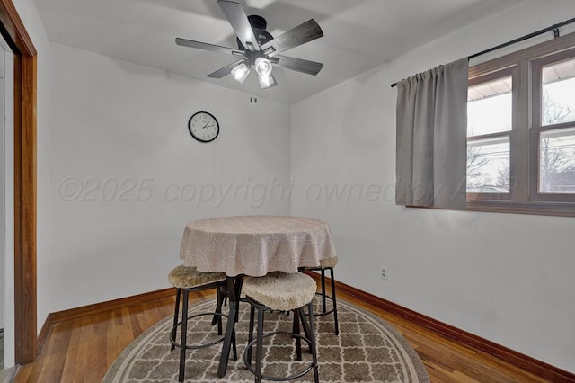 dining space with ceiling fan, baseboards, and wood finished floors