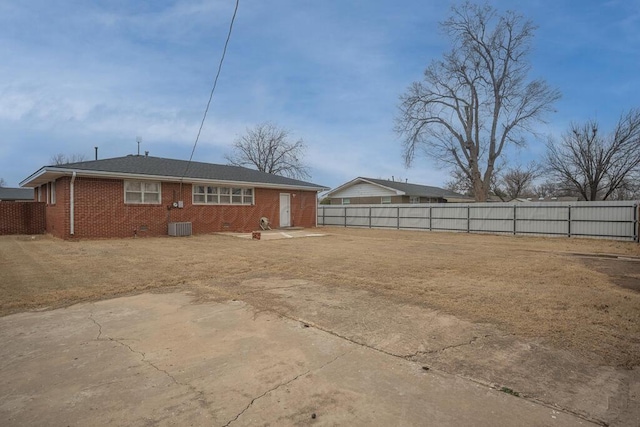 rear view of house featuring crawl space, brick siding, fence, and central AC unit