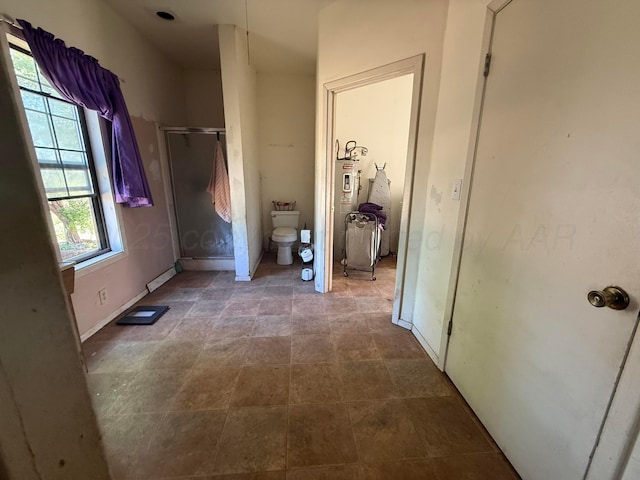 2107 Hemlock St, Borger, TX 79007 - bathroom with a stall shower, toilet, a baseboard heating unit, and baseboards