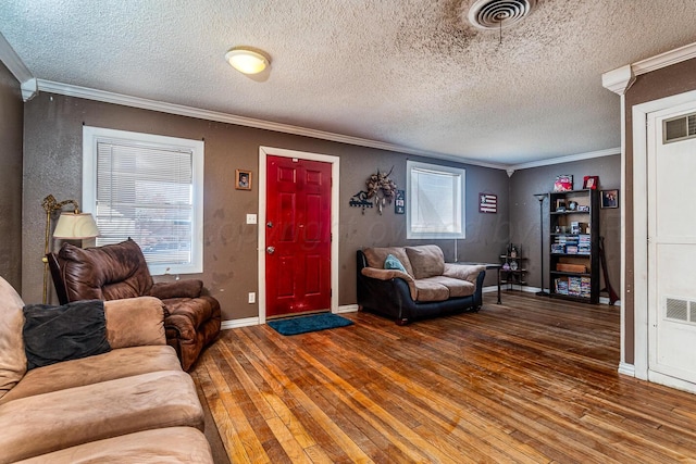 living area with crown molding, hardwood / wood-style flooring, and visible vents