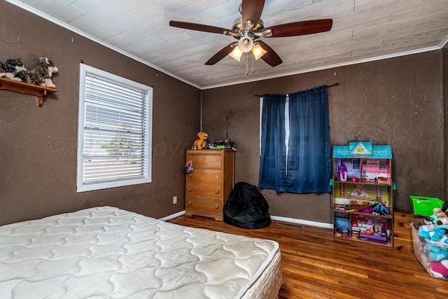 bedroom featuring visible vents, wood finished floors, ceiling fan, and ornamental molding