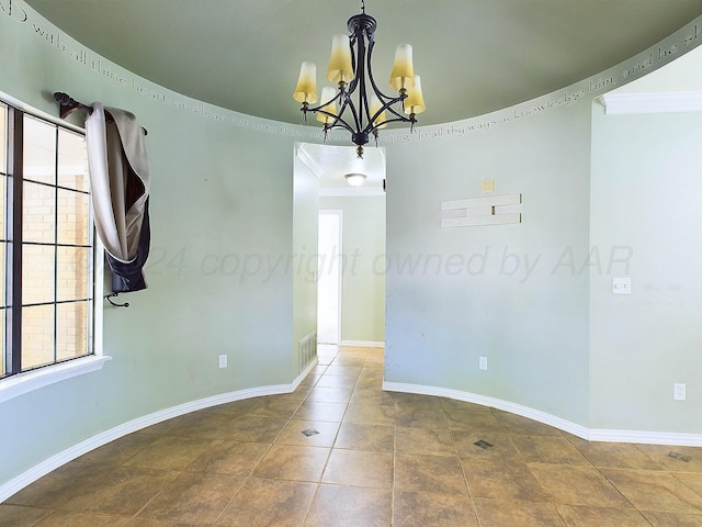 spare room with crown molding and a chandelier