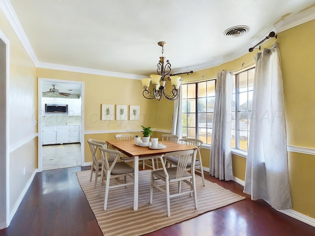 dining room with ceiling fan with notable chandelier, dark hardwood / wood-style floors, and ornamental molding