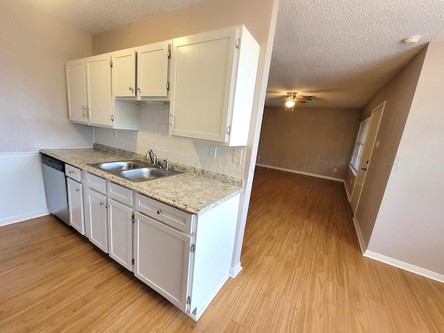1312 Coffee St, Pampa, TX 79065 - kitchen featuring light hardwood / wood-style flooring, sink, stainless steel dishwasher, white cabinets, and tasteful backsplash
