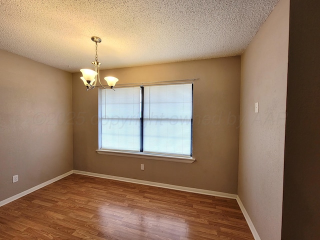 1312 Coffee St, Pampa, TX 79065 - unfurnished room featuring a textured ceiling, a notable chandelier, and wood-type flooring
