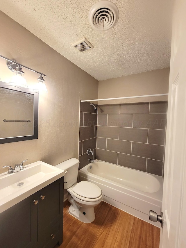 1312 Coffee St, Pampa, TX 79065 - full bathroom with vanity, a textured ceiling, tiled shower / bath combo, toilet, and hardwood / wood-style flooring