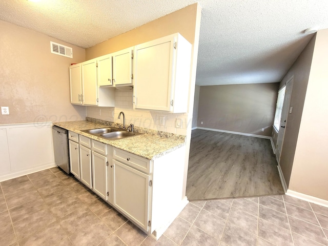 1312 Coffee St, Pampa, TX 79065 - kitchen with sink, stainless steel dishwasher, tasteful backsplash, and a textured ceiling