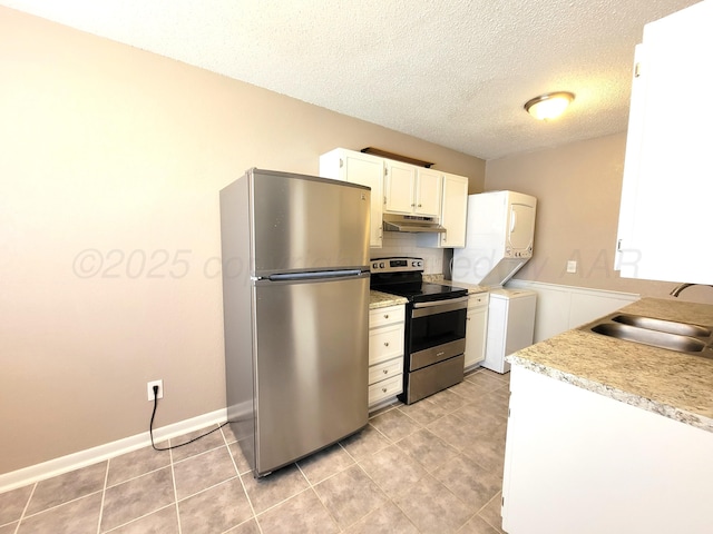 1312 Coffee St, Pampa, TX 79065 - kitchen featuring stacked washer and dryer, sink, stainless steel appliances, and white cabinetry
