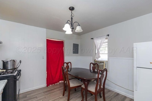 2503 SW 5th Ave, Amarillo, TX 79106 - dining space with a chandelier, light wood-style flooring, a wainscoted wall, cooling unit, and electric panel