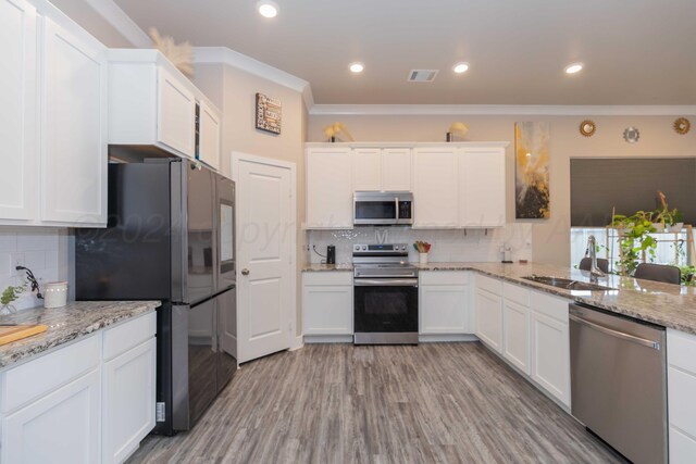 1738 Wesleyan St, Amarillo, TX 79118 - kitchen with ornamental molding, backsplash, appliances with stainless steel finishes, sink, and white cabinets