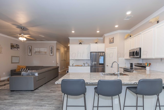 1738 Wesleyan St, Amarillo, TX 79118 - kitchen featuring stainless steel appliances, backsplash, sink, a breakfast bar, and white cabinets