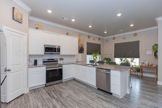 1738 Wesleyan St, Amarillo, TX 79118 - kitchen with white cabinetry, kitchen peninsula, and stainless steel appliances