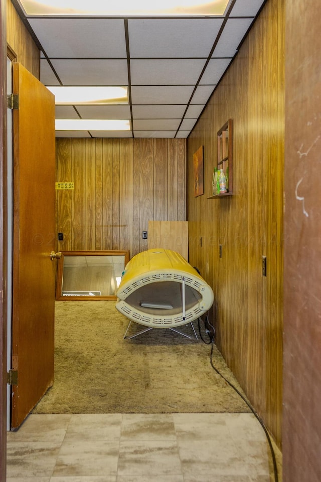 bathroom with wooden walls and a paneled ceiling