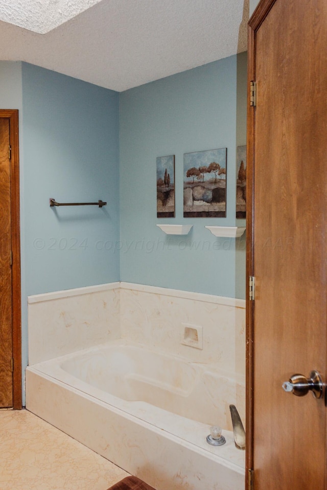 bathroom with a textured ceiling and a bathing tub