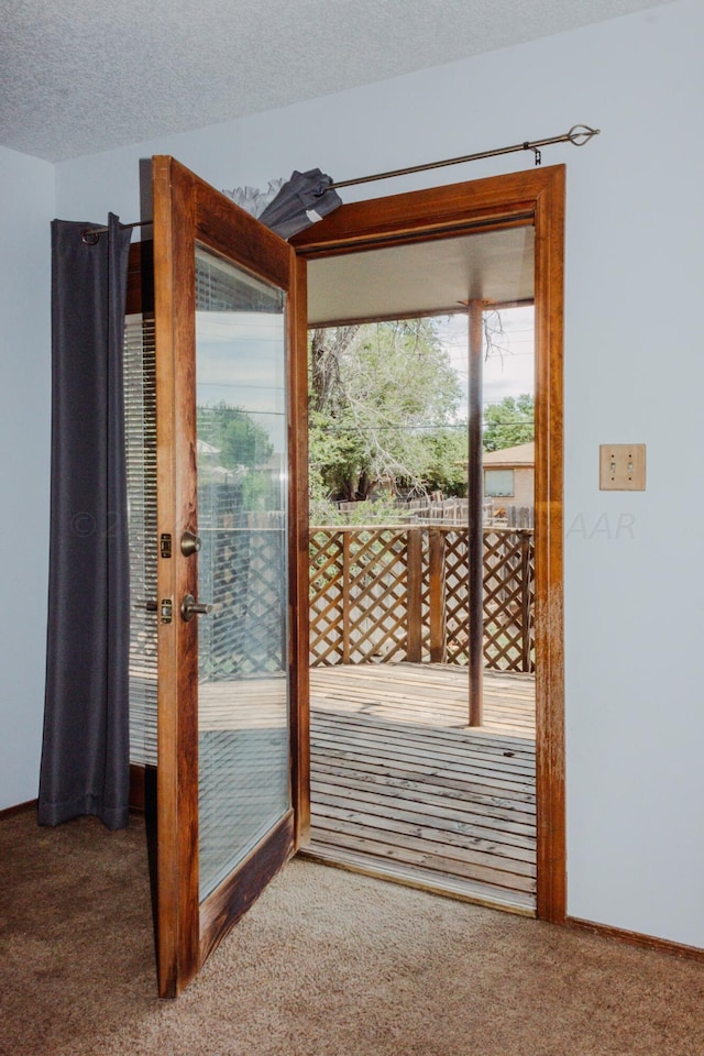 doorway featuring a textured ceiling and carpet floors