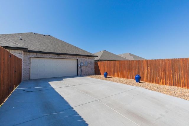6900 Tatum Cir, Amarillo, TX 79119 - view of property exterior with concrete driveway, brick siding, roof with shingles, and a garage