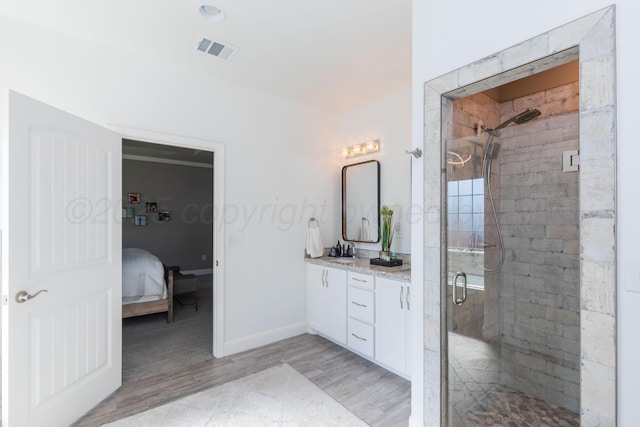 6900 Tatum Cir, Amarillo, TX 79119 - bathroom featuring wood finished floors, double vanity, a stall shower, and ensuite bathroom