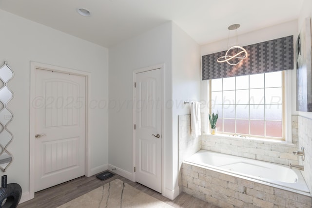 6900 Tatum Cir, Amarillo, TX 79119 - bathroom with healthy amount of natural light, a bath, a chandelier, and wood finished floors
