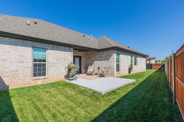 6900 Tatum Cir, Amarillo, TX 79119 - back of house with a shingled roof, a fenced backyard, a patio, and brick siding