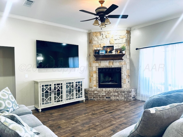 living room with dark hardwood / wood-style floors, ceiling fan, a stone fireplace, and ornamental molding