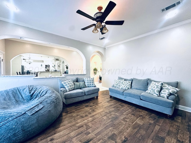 living room featuring ceiling fan with notable chandelier, dark hardwood / wood-style floors, and ornamental molding