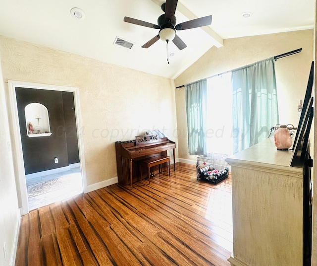 interior space featuring vaulted ceiling with beams, ceiling fan, and wood-type flooring
