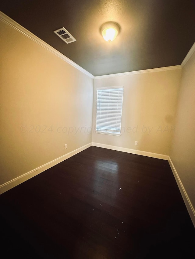 spare room featuring wood-type flooring and crown molding
